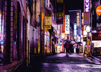 woman walking in the street during night time