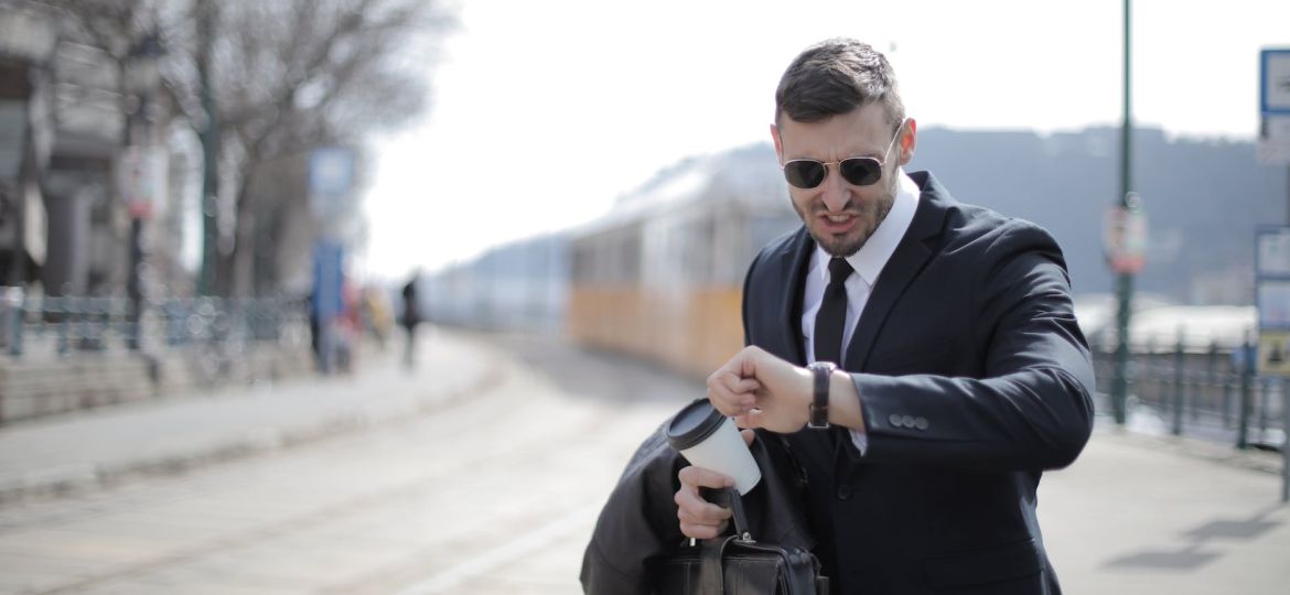 man in black suit jacket holding black leather bag