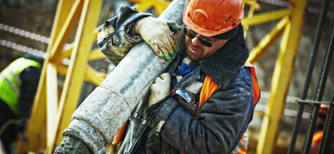 man carrying gray pipe