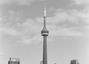 grayscale photo of tower and buildings