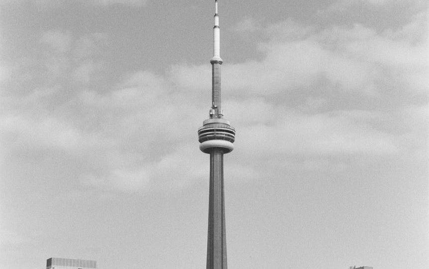 grayscale photo of tower and buildings
