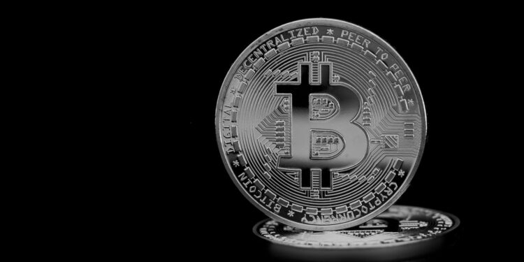 silver round coin on black surface